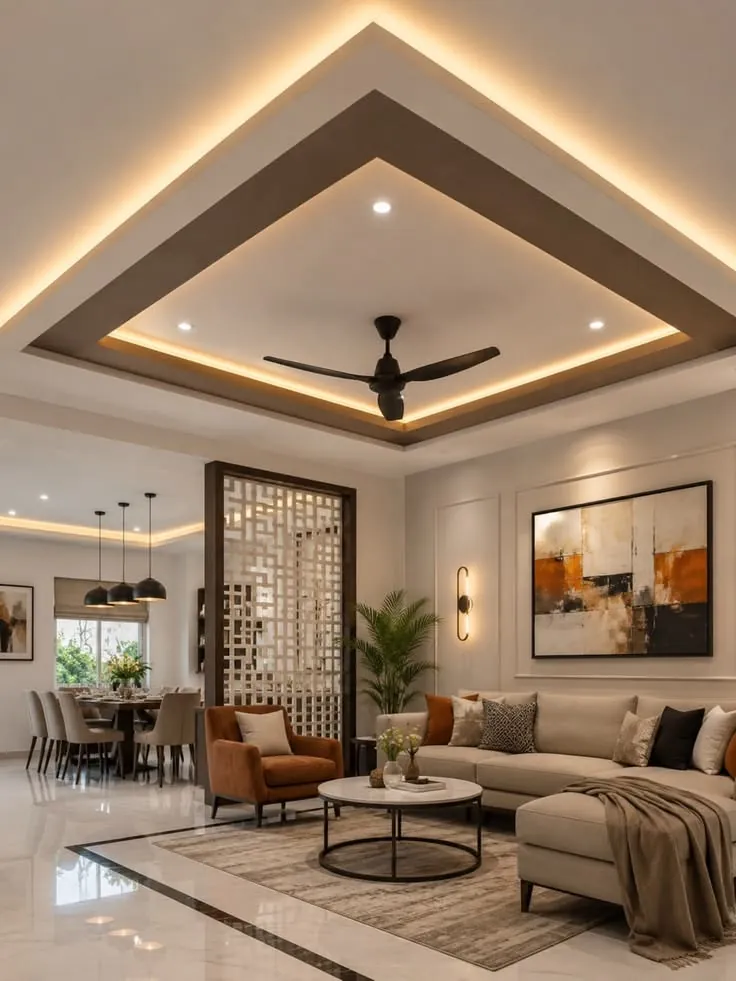 Open living and dining area with a layered false ceiling, sofa seating and a decorative partition